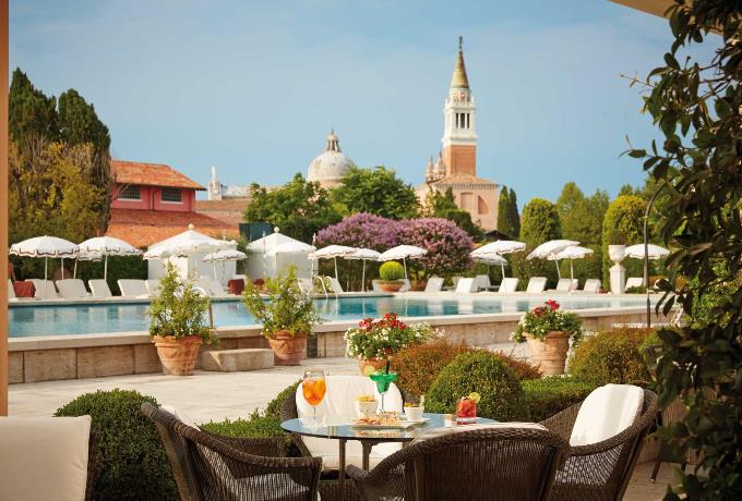 Belmond Hotel Cipriani pool with Venice skyline, offering exclusive Bellini Club perks like $200 credits and upgrades in 2026.</p>
<p>