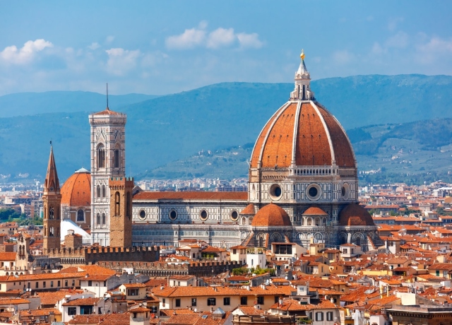 Florence Duomo Cathedral of Santa Maria del Fiore at golden hour with terracotta dome glowing in sunset light