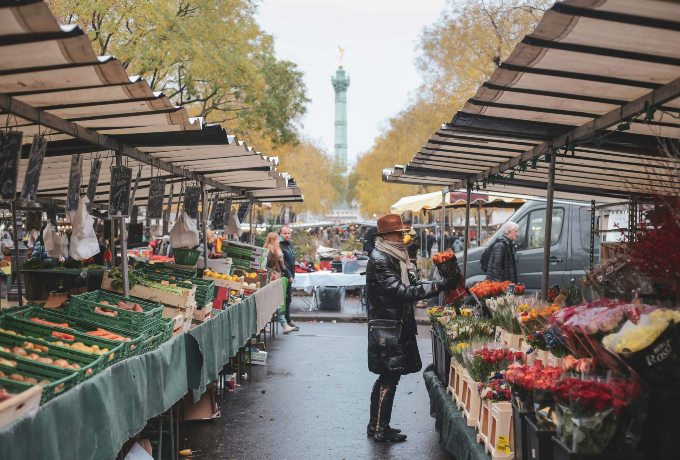 Woman buying fresh produce at a Paris market during a French cooking class and market tour