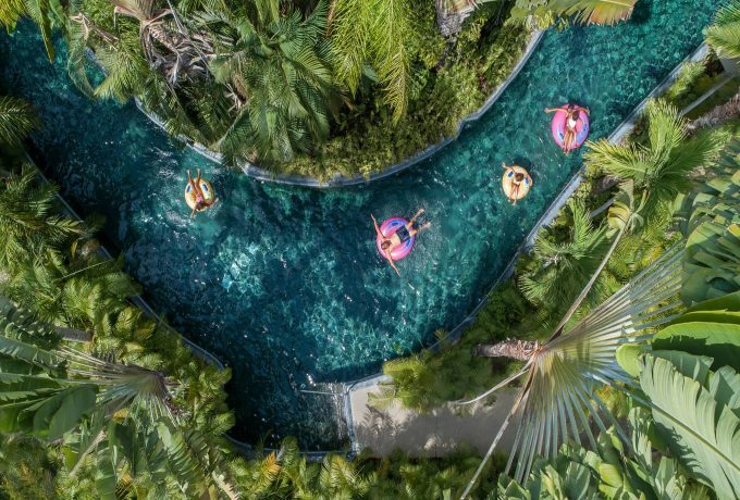 Guests floating along the lazy river at Four Seasons Punta Mita surrounded by tropical gardens