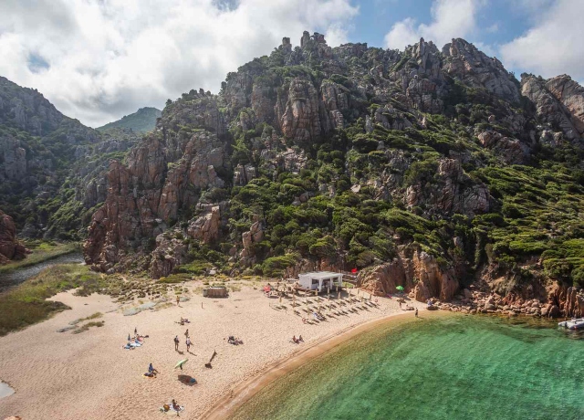 White sand beach in Sardinia with turquoise Mediterranean water and rugged coastline